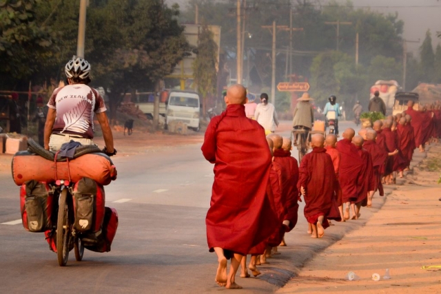monks and cyclist in Myanmar