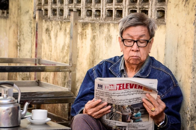 man reading newspaper in Myanmar